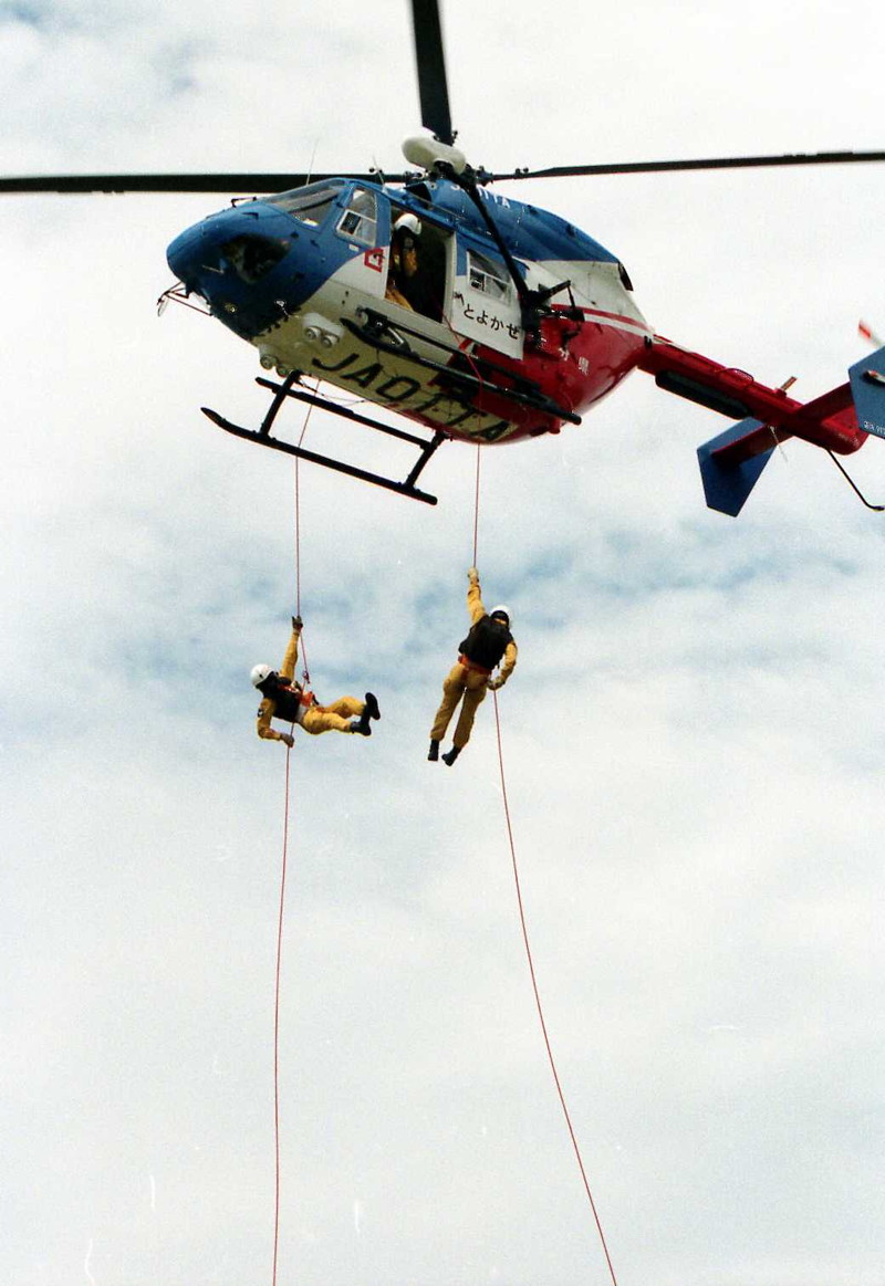 防災航空隊／ヘリコプターから、ロープを伝って隊員が救助に向かう