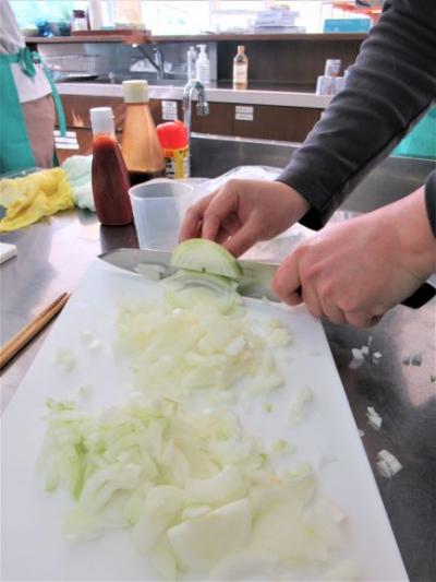 栄養講座の調理実習で玉ねぎを切っています